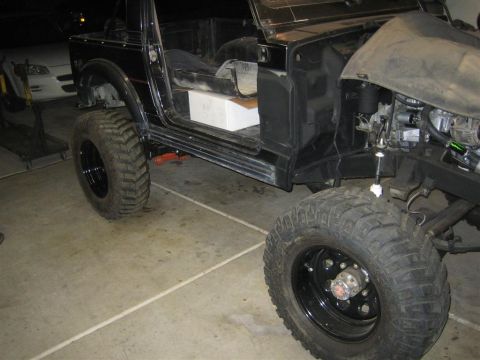 1987 Suzuki Samurai - A black off-road vehicle is shown with its doors removed and the engine compartment partially visible.