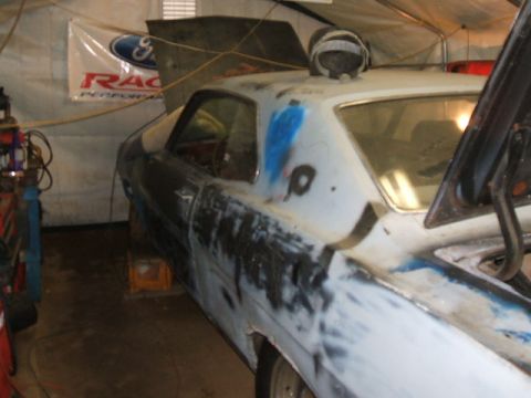 1969 Ford Torino - A 1969 Ford Torino in primer, possibly undergoing restoration, is shown in a garage setting.