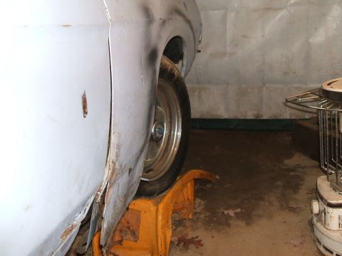 1969 Ford Torino - Side view of a 1969 Ford Torino's fender and wheel, resting on a jack stand.