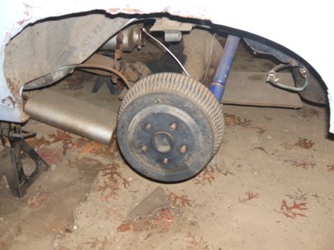 1969 Ford Torino - The rear suspension of a 1969 Ford Torino, including the drum brake and shock absorber, is visible while supported by jack stands.