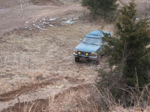 1996 Ford Bronco - Teal 1996 Ford Bronco navigates a dirt track in a rural, outdoor setting.