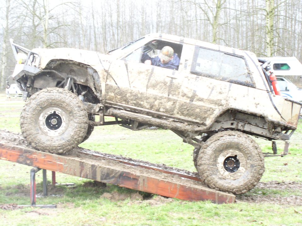 Muddy off-road vehicle on a ramp, side view