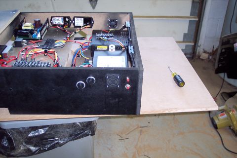 2001 Ford Crown Victoria - An open electronic control box with visible wiring and components, next to a wooden surface with a screwdriver.