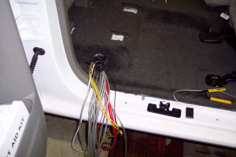 2001 Ford Crown Victoria - A close-up view of the interior of a vehicle, showing a bundle of electrical wires and a pair of wire cutters.