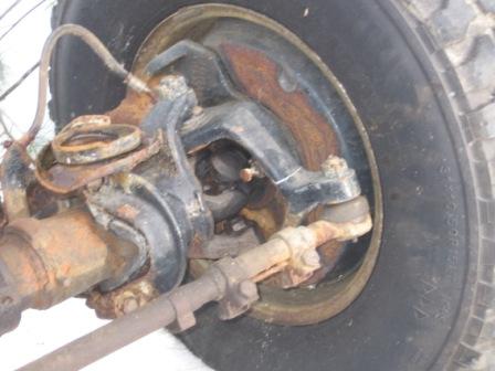 1993 Ford Bronco - Close-up of a vehicle's front suspension and wheel assembly, showing significant rust.