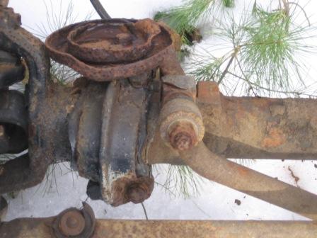 1993 Ford Bronco - Close-up of a heavily rusted front axle assembly, likely from an older vehicle.