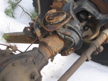 1993 Ford Bronco - Close-up of heavily rusted vehicle suspension components, suggesting significant age and disuse.