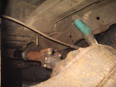 1979 Ford Bronco - Underside view of a vehicle's rear axle and driveshaft components, showing rust and wear.