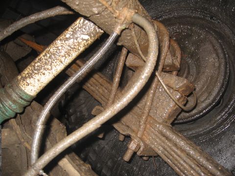 1979 Ford Bronco - The rear axle and suspension are covered in mud, obscuring details.