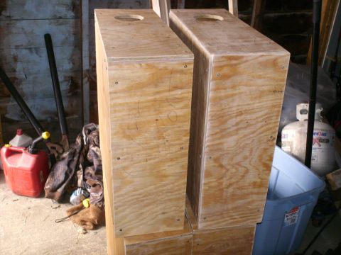 1983 Ford Bronco - Two unfinished wooden boxes with holes on top sit in a cluttered garage setting.