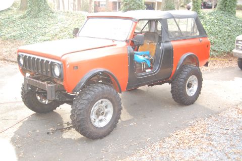1994 Ford Bronco - This lifted SUV, possibly an International Harvester Scout, is shown with its doors removed and large off-road tires.