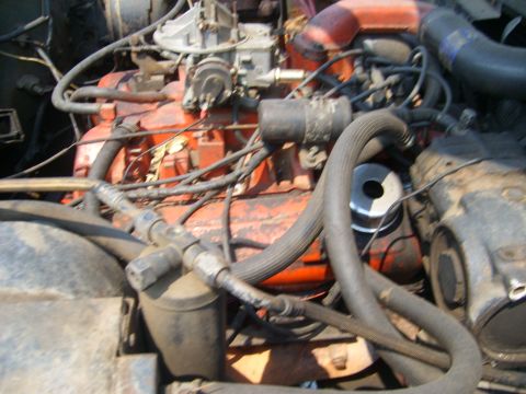 1994 Ford Bronco - The engine compartment shows various hoses, wiring, and the carburetor assembly.