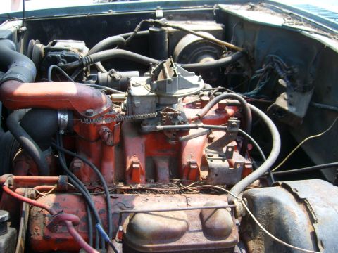 1994 Ford Bronco - Close-up view of an engine bay, a red intake manifold and carburetor, with visible hoses and wiring.
