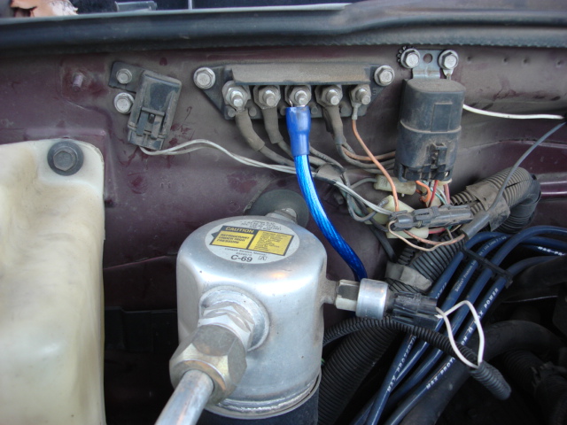 ok time to get power to the power block under the pass seat. on the firewall on the pass side under a plastic cover (held on by 3 plastic nuts) is a power disti block. i ran the amp power wire to it and selected a bolt. (all have the same power)