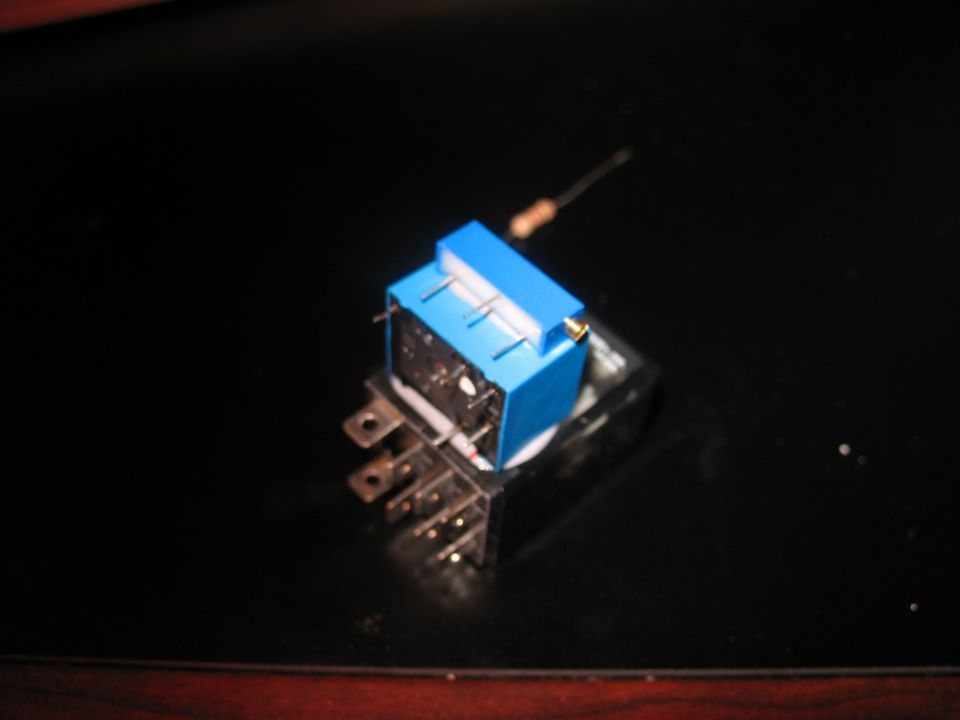 Blue relay with a resistor on a black surface