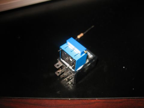 1995 Ford C-350 (Centurion Conversions) - Close-up of a blue automotive relay switch with a resistor. The part is on a dark surface.