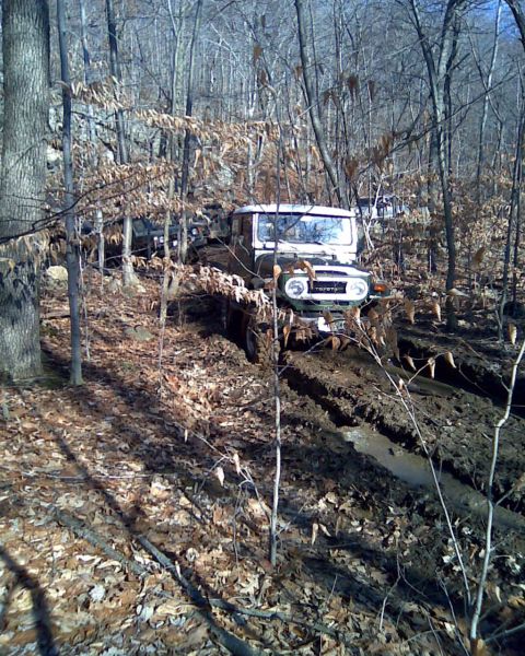 1989 Ford Bronco - This classic Toyota Land Cruiser is navigating a muddy, wooded path.