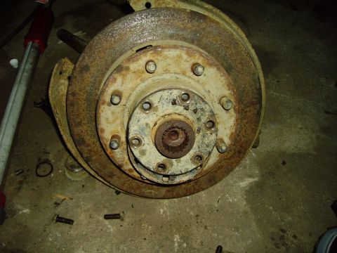 1991 Ford Bronco - Close-up of a heavily rusted brake rotor and hub assembly, likely from an older vehicle, showing wear and tear.