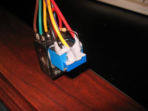 1995 Ford C-350 (Centurion Conversions) - Close-up of an automotive relay with wires attached, some held by white adhesive.