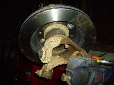1991 Ford Bronco - Close-up of a brake rotor and hub assembly, held securely in a vise for work.