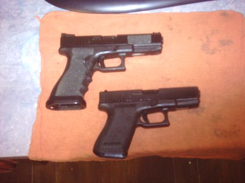 1996 Ford Bronco - Two handguns are laid out on an orange cloth, with a dark surface above and a wooden surface below.