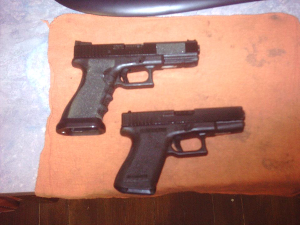 two black handguns on an orange cloth