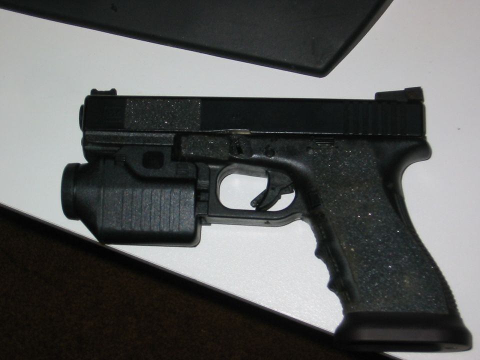 Pistol with mounted flashlight, side view
