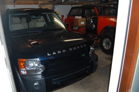 1994 Ford Bronco - A Land Rover Discovery is parked in a garage, with another vehicle partially visible behind it.