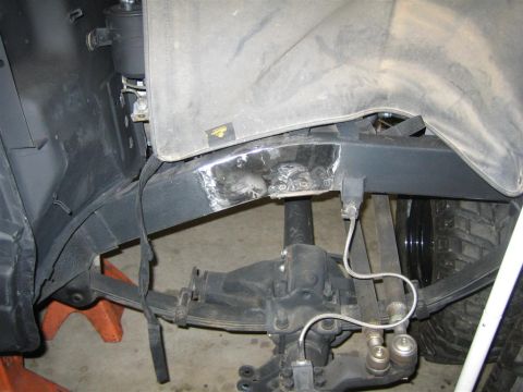 1987 Suzuki Samurai - Rear wheel well of a 4x4 up on jack stands, showing freshly ground weld beads where the fender lip and inner structure were cut and re-weld…