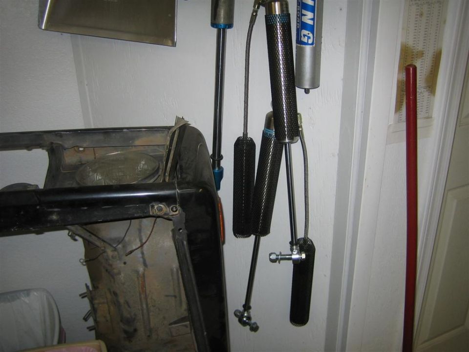 Vehicle frame section with black bumper and suspension shocks hanging nearby