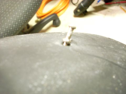 1994 Ford Bronco - A tire valve stem is pierced by a nail, indicating a flat tire.
