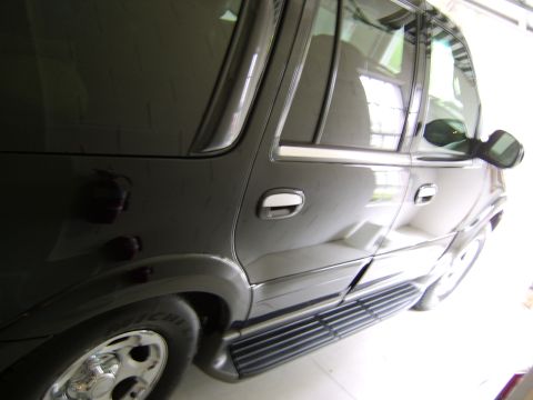 1996 Mercury Grand Marquis - Side view of a black SUV, running boards and chrome accents.