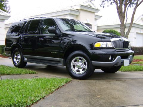 1996 Mercury Grand Marquis - A black Lincoln Navigator is parked on a concrete driveway in front of a suburban home.