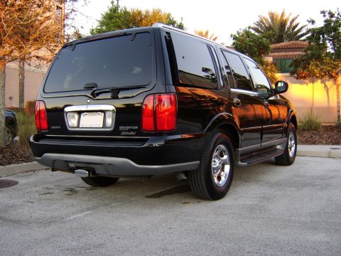1996 Mercury Grand Marquis - Rear view of a black Lincoln Navigator Limited SUV parked outdoors during sunset.