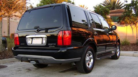 1996 Mercury Grand Marquis - Rear view of a black Lincoln Navigator Limited SUV parked outdoors.
