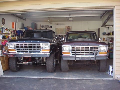 1979 Ford Bronco - Two Ford Broncos from the 1979 model year are parked inside a garage.