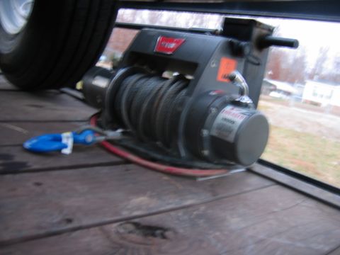 1992 Ford Mustang - A winch is mounted on a wooden trailer deck, with a tire visible in the background.