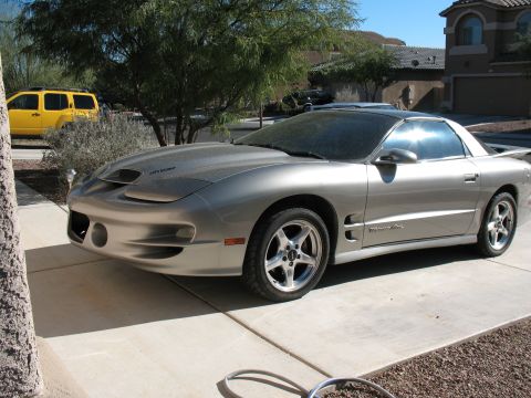 2001 Pontiac Trans Am - Silver 2001 Pontiac Trans Am parked on a driveway with a yellow SUV in the background.