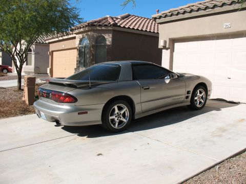 2001 Pontiac Trans Am - Silver 2001 Pontiac Trans Am parked in a driveway with a house and garage in the background.