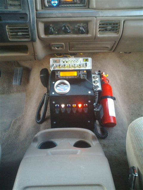 1994 Ford Bronco - The vehicle's interior features a CB radio, gauge, and auxiliary switches, along with a mounted fire extinguisher.