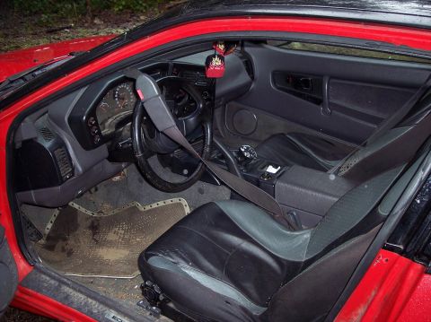 1991 Mitsubishi Eclipse - Interior view of a red car, showing the driver's seat, dashboard, and center console.