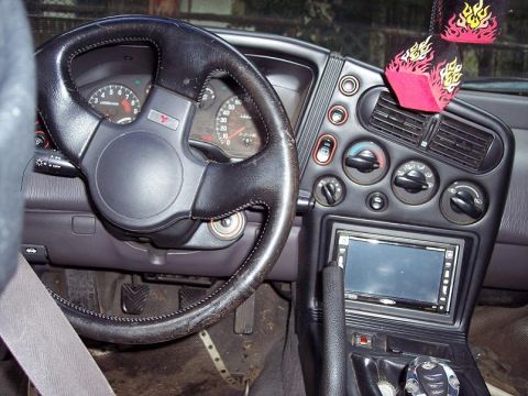 1991 Mitsubishi Eclipse - The interior of a 1991 Mitsubishi Eclipse shows a custom stereo system and flame dice air freshener.