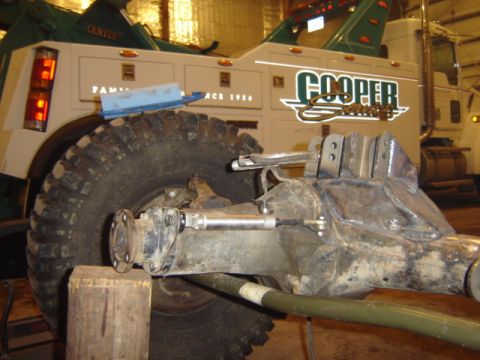 1992 Ford Bronco - Close-up of a tow truck's rear axle and wheel assembly, with company branding visible.