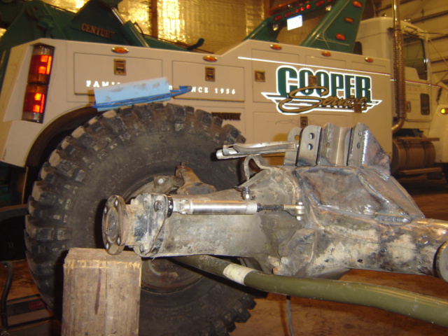 Tow truck rear axle assembly and large tire, with 'Cooper Service' text on the truck body