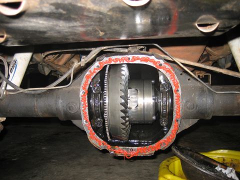 1996 Ford Bronco - Close-up of an open differential housing, showing the internal gears and a bead of orange sealant.