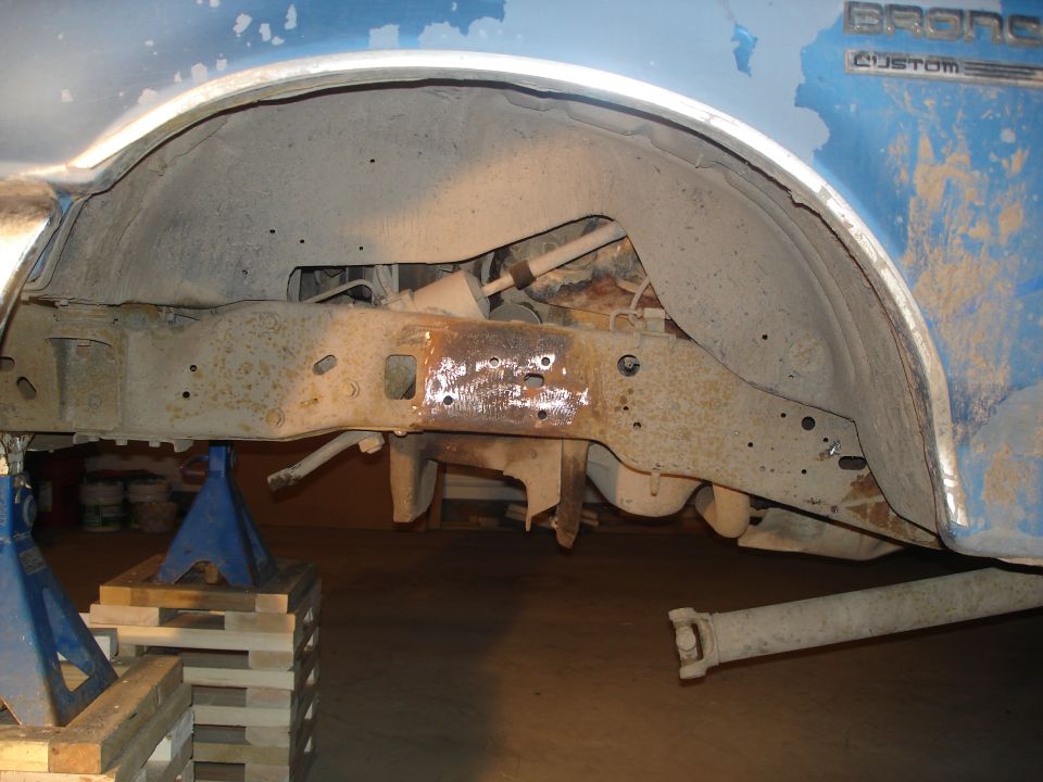 1990 Ford Bronco rear wheel well and frame, supported by jack stands