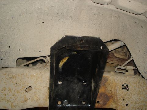 1990 Ford Bronco - Underside view of a vehicle's frame with a suspension bracket and related components.