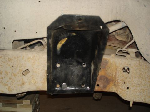 1990 Ford Bronco - A black bracket is attached to the frame of a vehicle, showing signs of rust and wear.