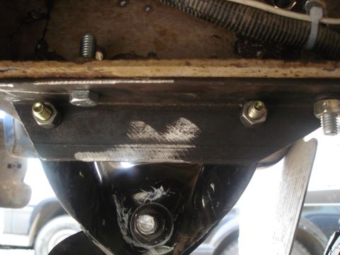 1990 Ford Bronco - Close-up view of an underbody component with visible bolts and wiring, the Supermotors.net logo.