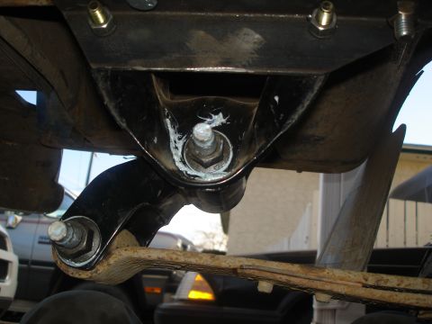 1990 Ford Bronco - Underside view of a vehicle's suspension system, showing a leaf spring and mounting hardware.